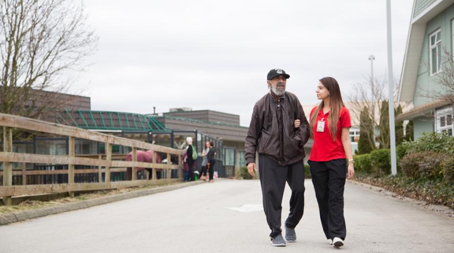 man walking outside with woman in hospital scrubs