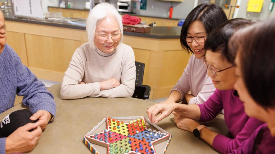 Group of people playing board game in a community centre