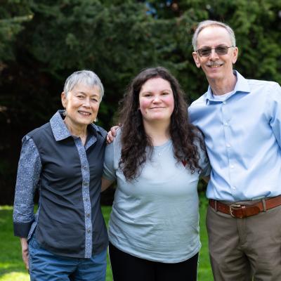 Three people posing in a park.