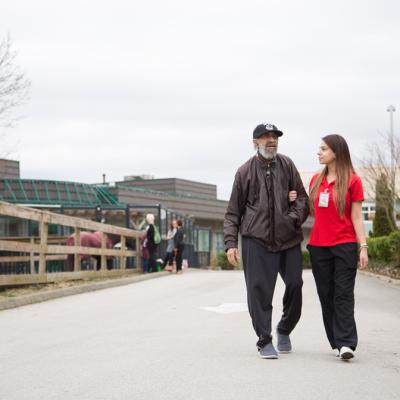 man walking outside with woman in hospital scrubs