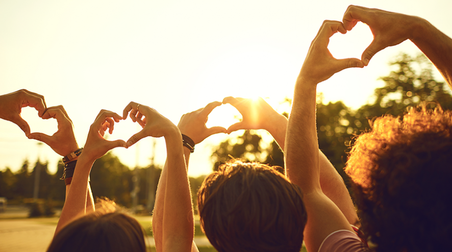 Hands making heart shapes toward the sky