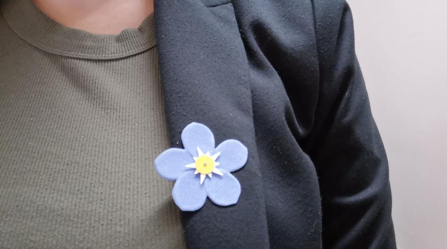 Close up of forget-me-not flower stick pin
