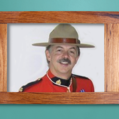 Photo of Patrick in a wooden frame, hanging on a teal wall