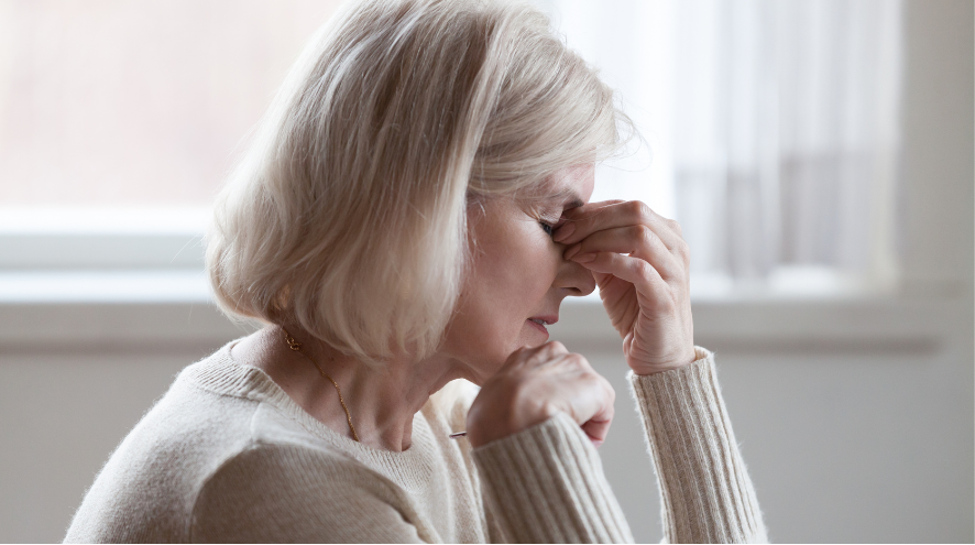 Woman touching face with hand in a stressful manner