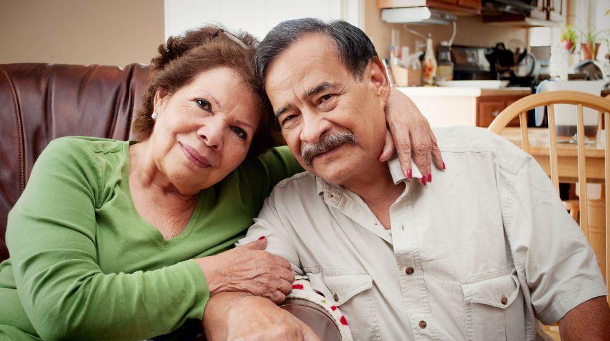 A man and woman sitting on a couch and holding each other