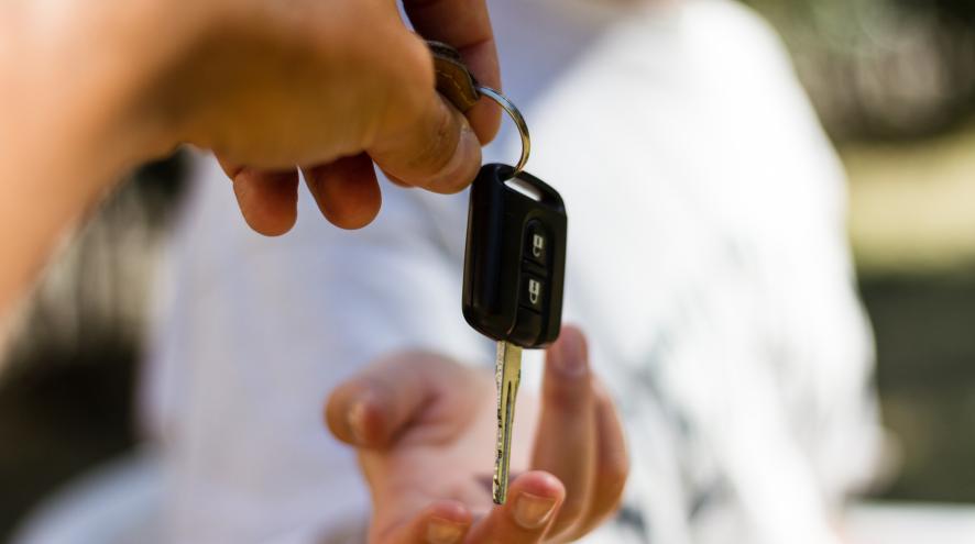 Person handing over keys to a car