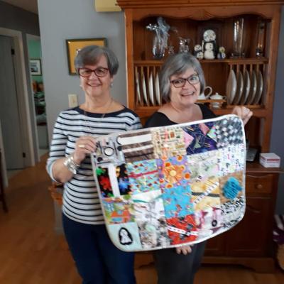 Cathy Dunbar & Beth McBrine pose with their 1,000th fidget quilt