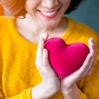 Woman holding stuffed fabric heart
