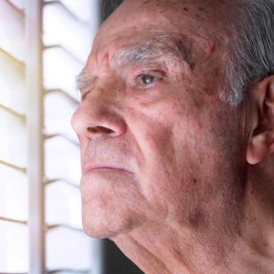 older-man-looking-worriedly-out-window