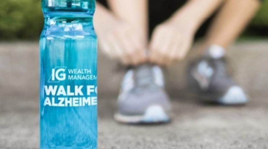 Person tying their shoes behind their water bottle branded with the IG Wealth Management Walk for Alzheimer's logo.