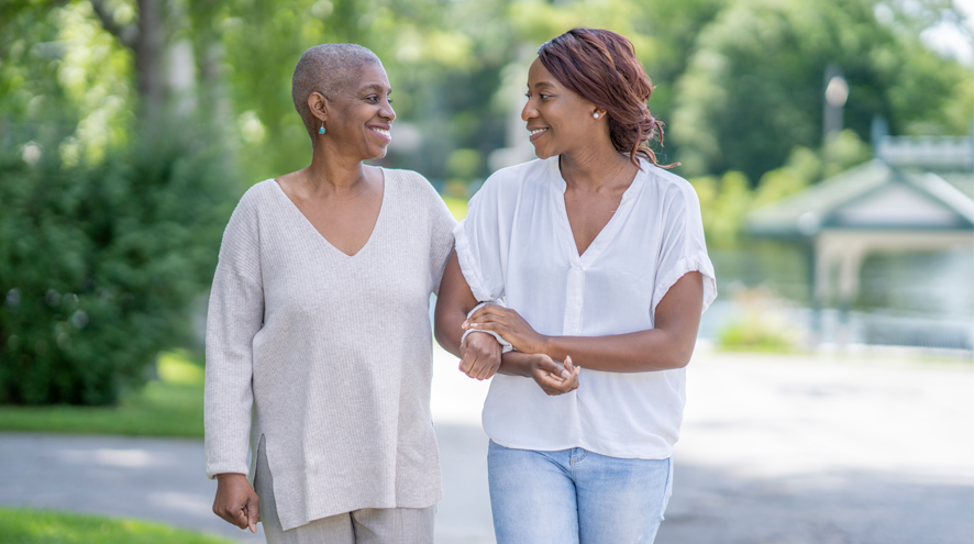 Two happy women holding hands, walking and smiling