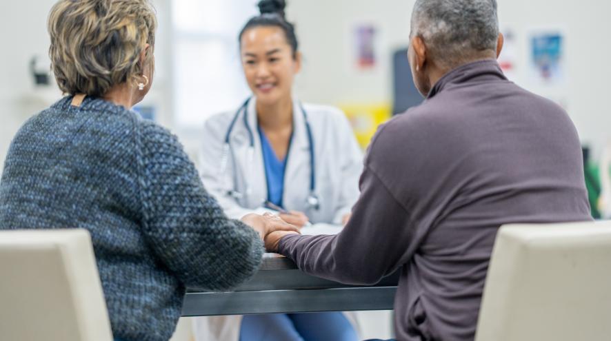 Doctor sitting with a man and woman