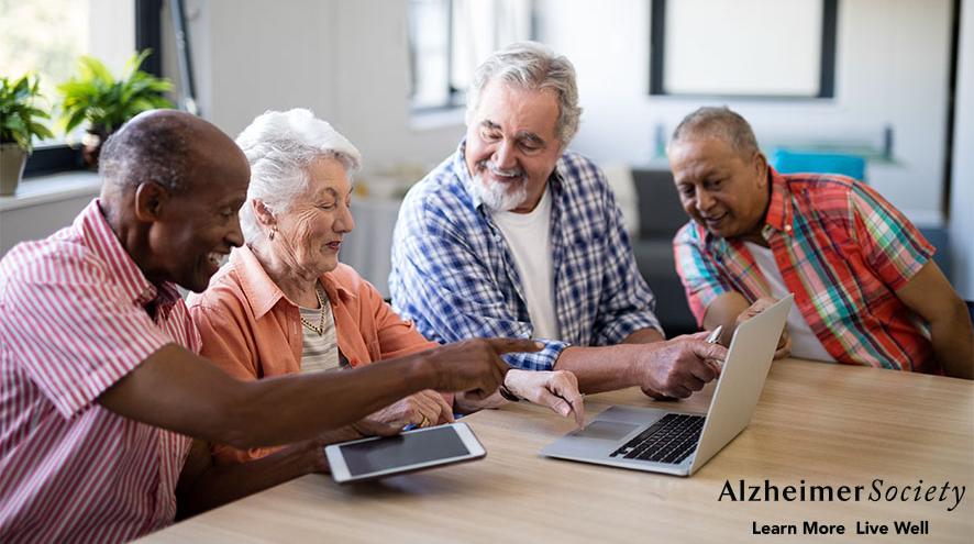 A group of people looking at laptops at the library
