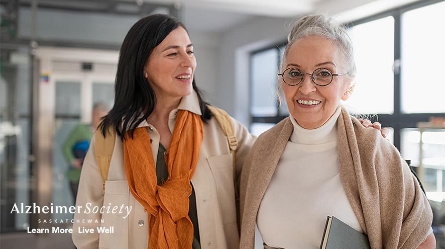 Two women standing outside a learning space smiling. 