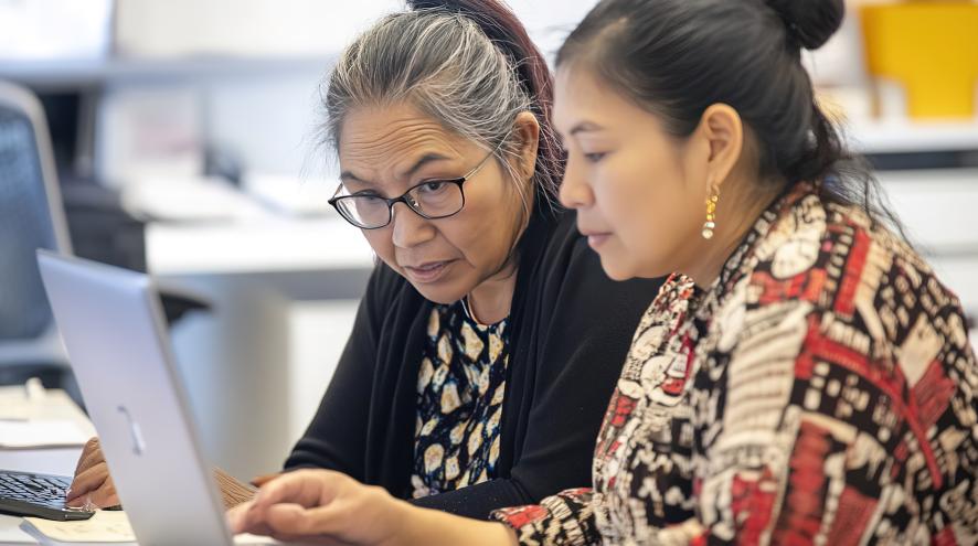 two women looking at a laptop