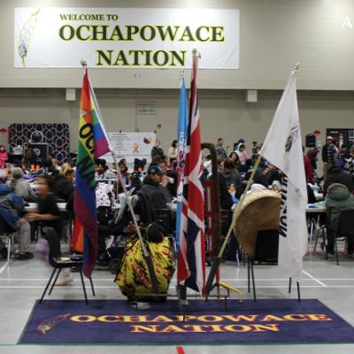 People visiting at tables in the Ochapowace Nation multi-plex.