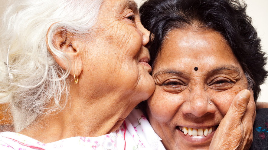 Senior mother kisses daughter's head