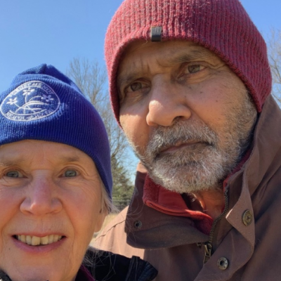 Jennifer Dance Bowen and Feroze outside in a selfie under a blue sky.